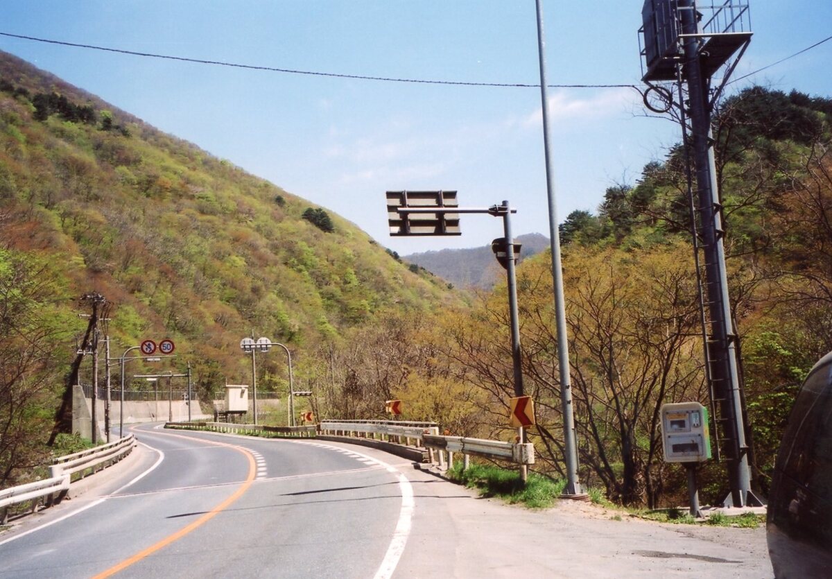 〔写真〕現国道48号線（右手が旧道への入口）/三島県令道路改修記念画帖　其之三　北村山郡関山村新道ノ内字小屋ノ原ヨリ関山隧道ヲ望ム図